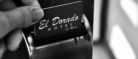 A hand inserting a card into a slot with the text "El Dorado Hotel" visible.