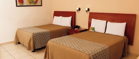 Two twin beds with brown bedding, a nightstand with a phone and a green item, and a painting on the wall.