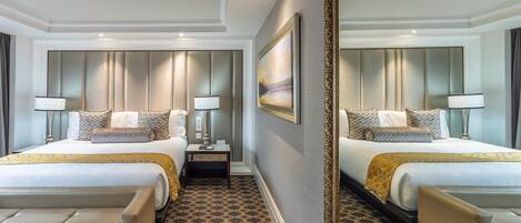 A hotel room with two beds, a large mirror, and a patterned floor.