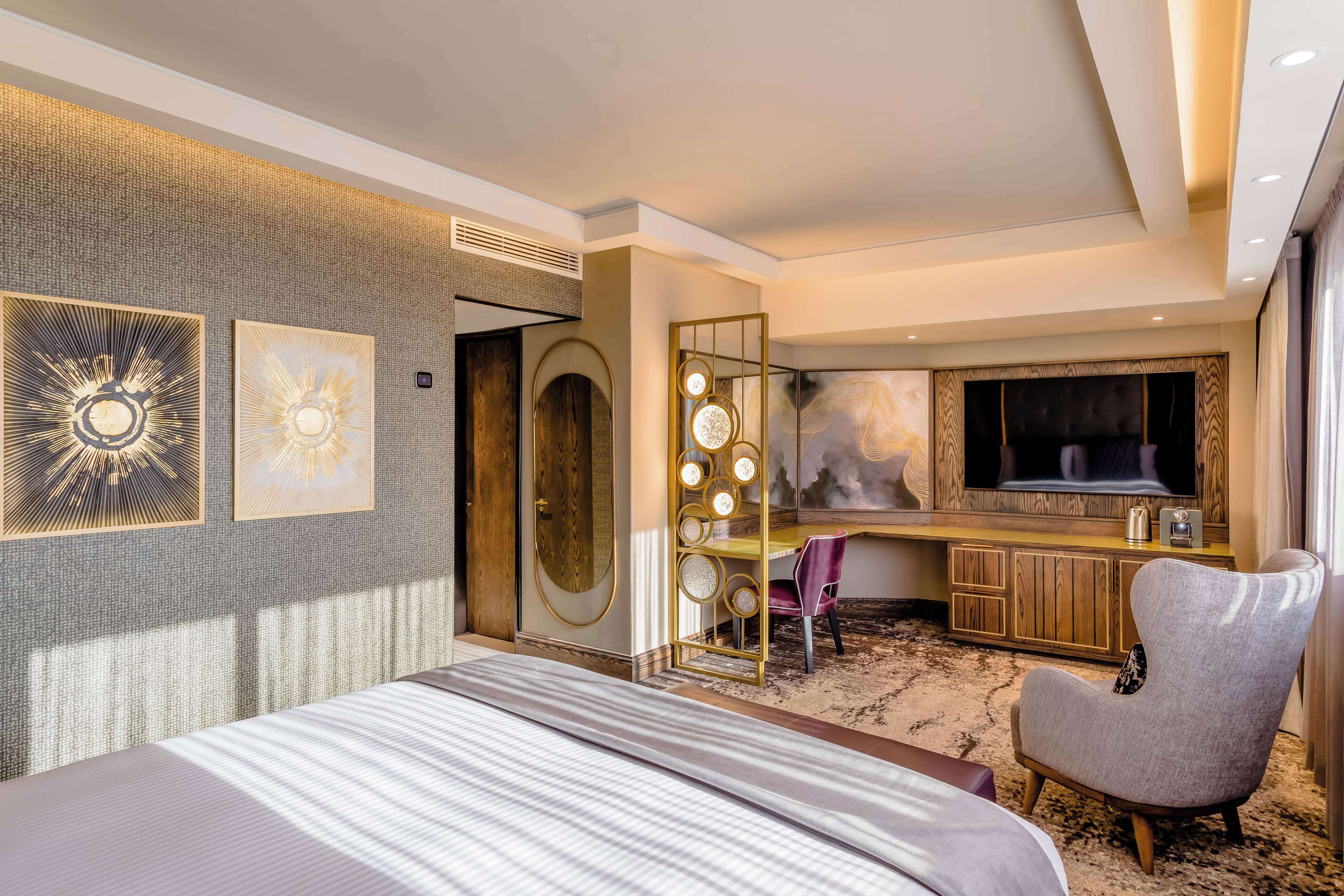 Une chambre d’hôtel avec un grand lit, une télévision, un bureau et une chaise.