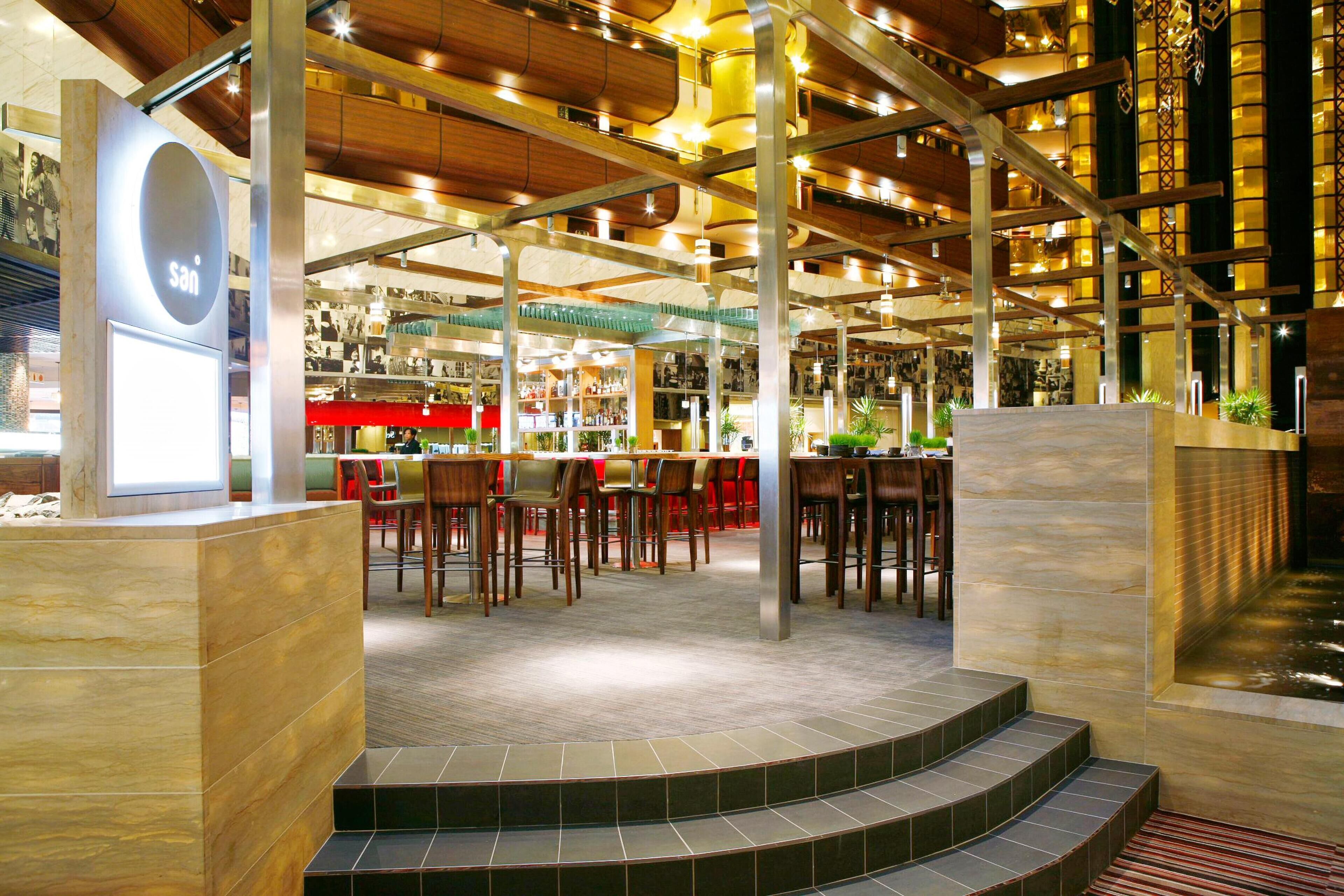 A spacious indoor area with multiple seating arrangements and a bar area.