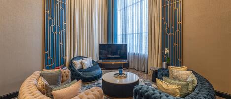 Una sala de estar moderna con un televisor de pantalla plana grande, asientos cómodos y cortinas decorativas.