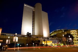 Un hotel moderno y alto, con una torre vertical destacada y un edificio curvo.