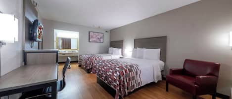 A hotel room with a bed, a desk, a chair, and a TV.