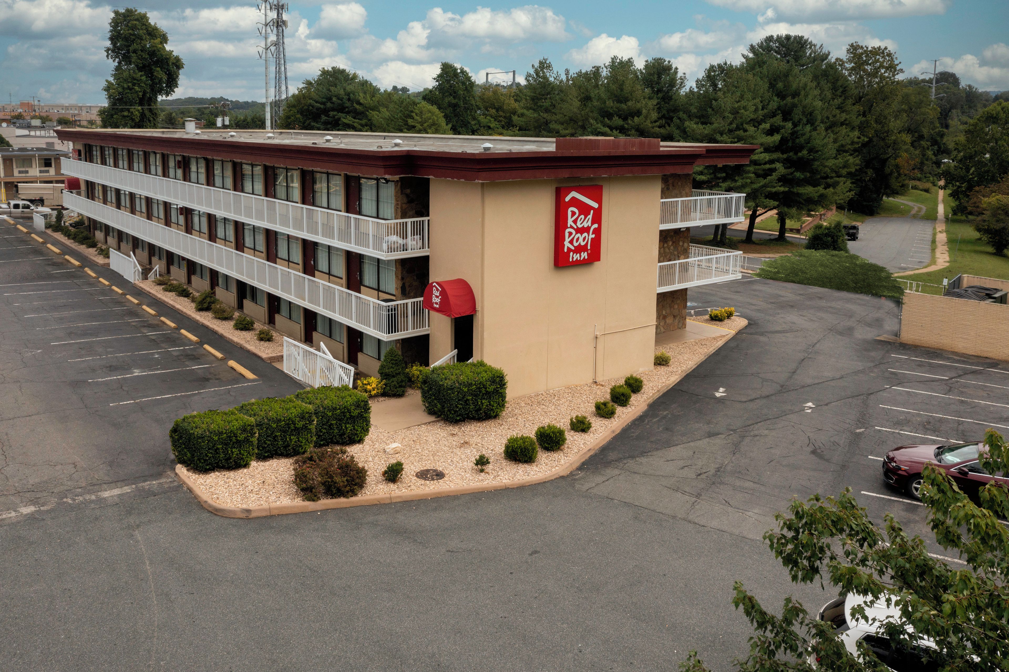 Un Red Roof Inn con estacionamiento, una galería techada y vistas del entorno.