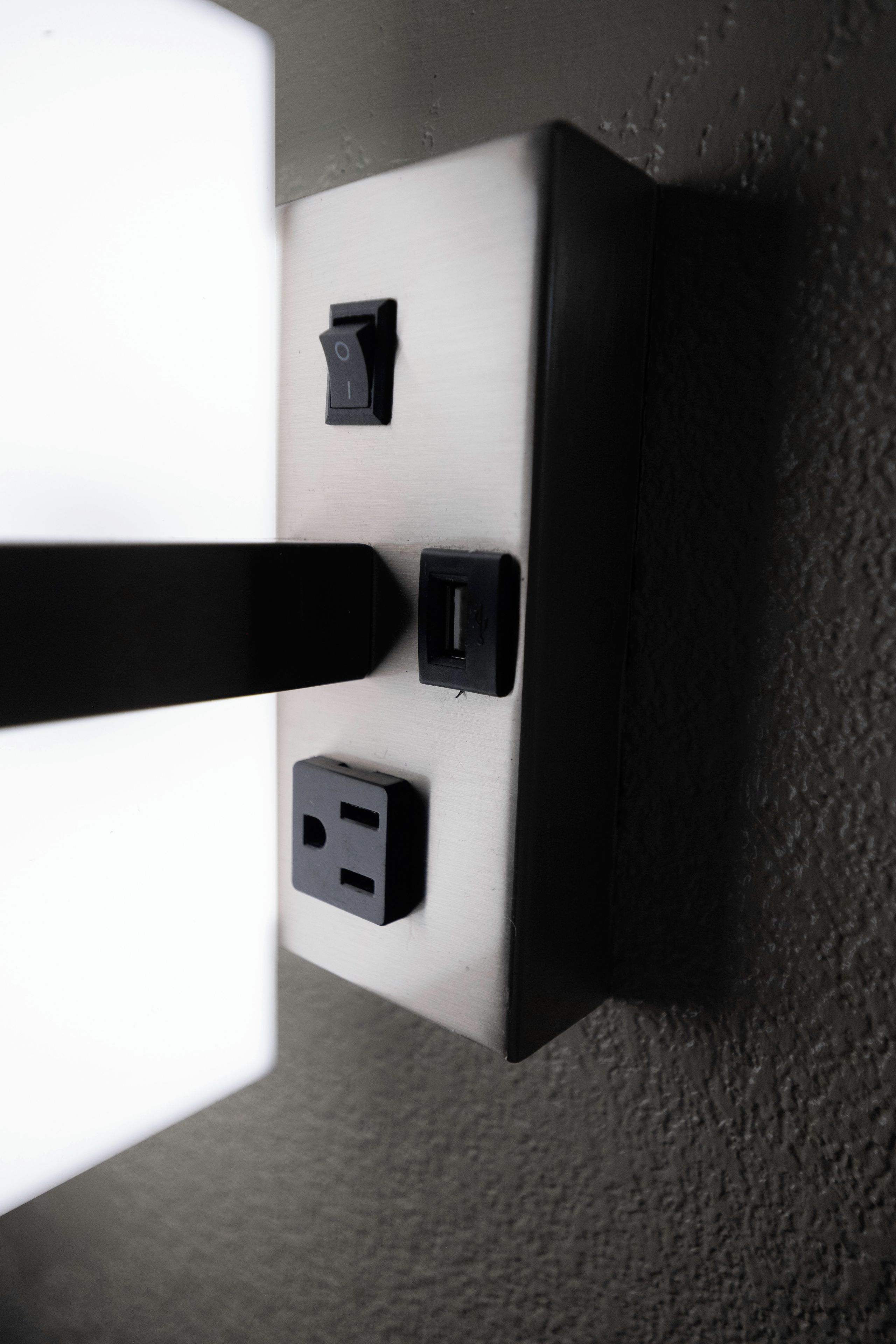 A wall-mounted electrical outlet with a switch and a plug socket.