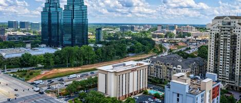 A cityscape with modern buildings, a large intersection, and surrounding greenery.