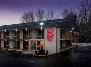 Un Red Roof Inn de dos pisos, con estacionamiento techado y entrada visible.