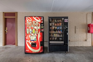 Two vending machines, one with a Coca-Cola design and the other with snacks, against a brick wall. - Red Roof Inn Fredericksburg North (Fredericksburg)