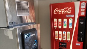 Ein Getränkeautomat mit Coca-Cola Logo und Wasserspender.