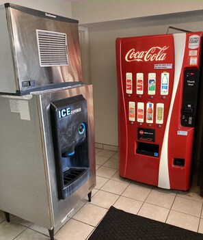 A vending machine with a Coca-Cola logo and a water dispenser. - HomeTowne Studios by Red Roof East Lansing - Okemos (Okemos)