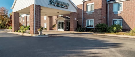 Un edificio de ladrillo de dos pisos con un acceso cubierto que dice 'Hometown Studios'.