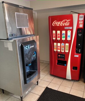 A vending machine with a Coca-Cola logo and an ICE dispenser. - HomeTowne Studios by Red Roof East Lansing - Okemos (Okemos)