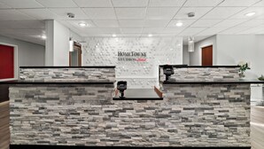 Un comptoir d’accueil avec un décor arrière imitant la pierre et une enseigne indiquant « HOMETOWNE STUDIOS ».