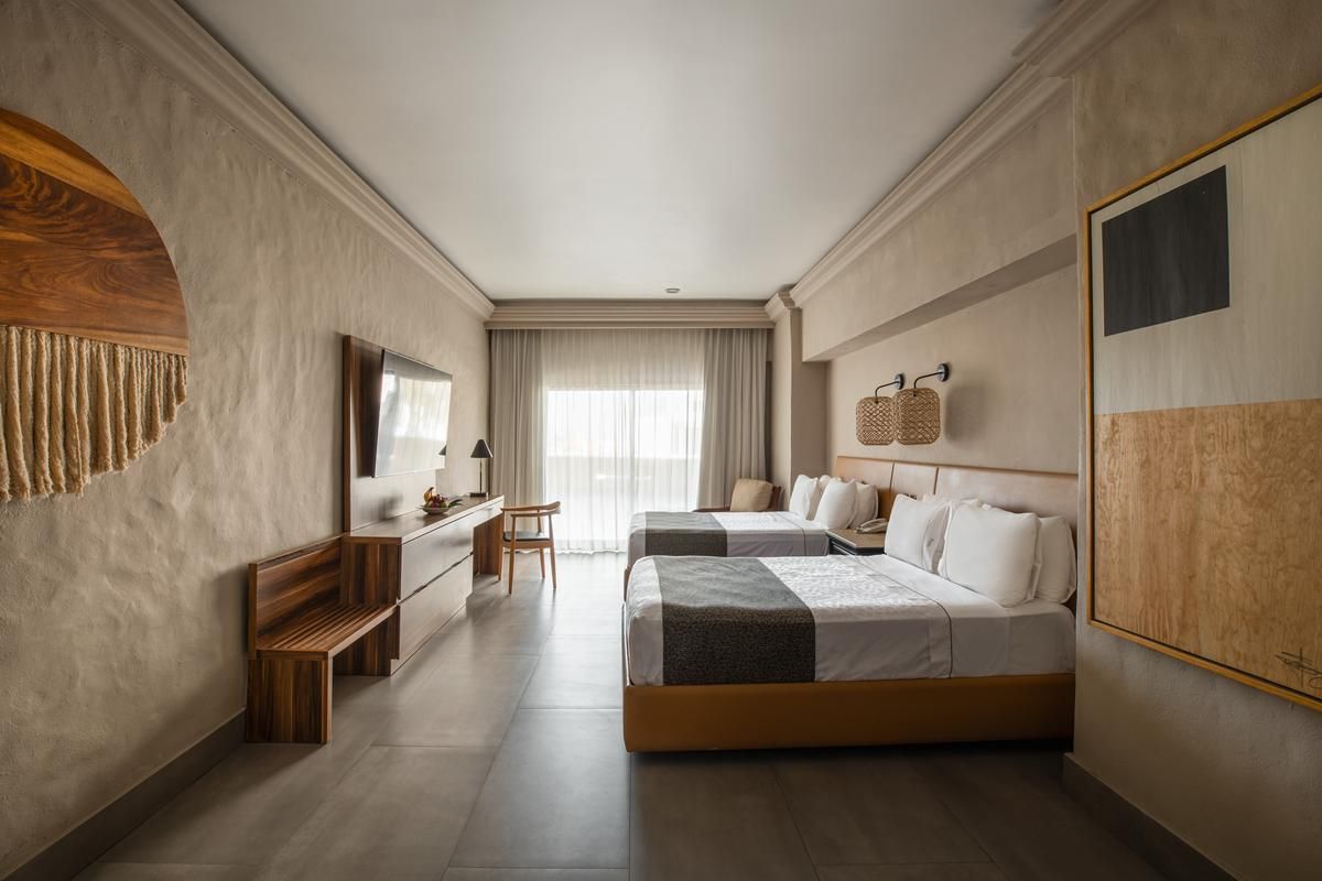 Une chambre d’hôtel avec un grand lit, un bureau, une chaise et un téléviseur.