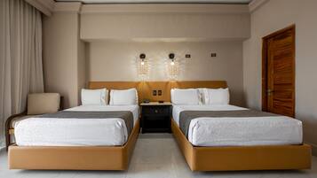 Ein Hotelzimmer mit zwei Betten, einem Nachttisch, einem Stuhl und einer Holztür.