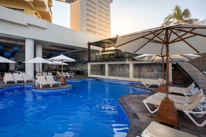 A swimming pool with lounge chairs and umbrellas, a staircase, and a building with a modern design. - Royal Villas Resort (Mazatlán)