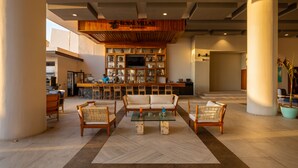 A spacious lobby with a bar area, comfortable seating, and a television. - Royal Villas Resort (Mazatlán)