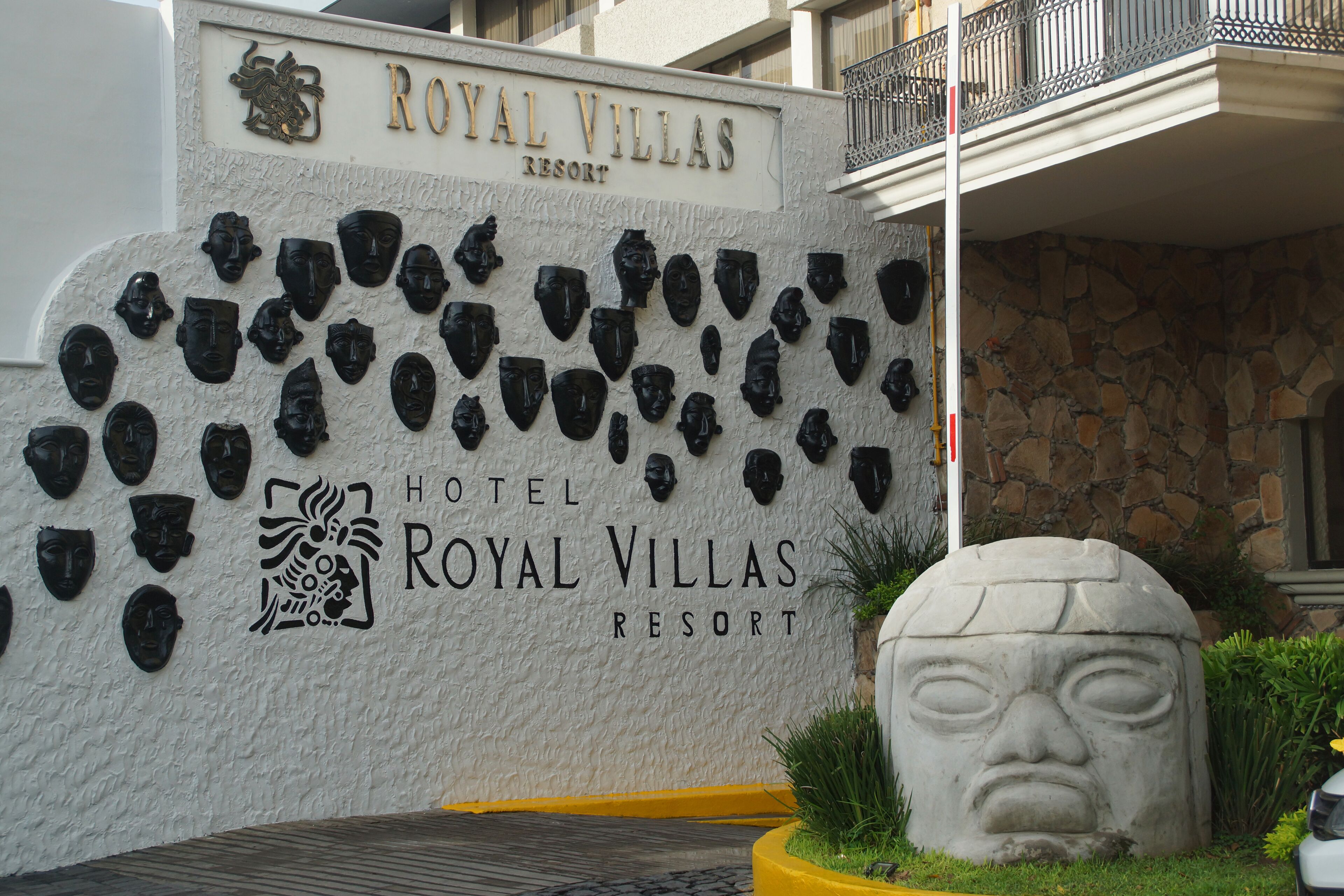 A wall with numerous black masks and the text "ROYAL VILLAS RESORT HOTEL".