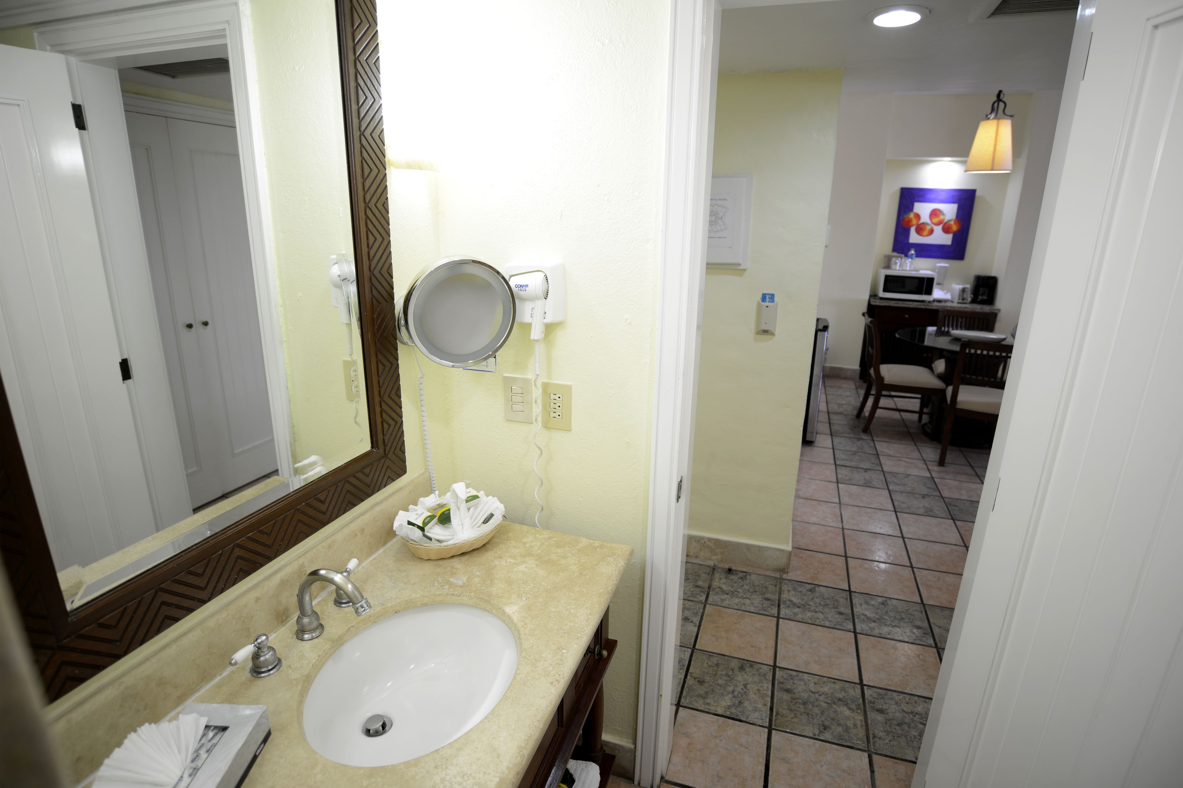 A bathroom with a sink, mirror, and a towel rack.