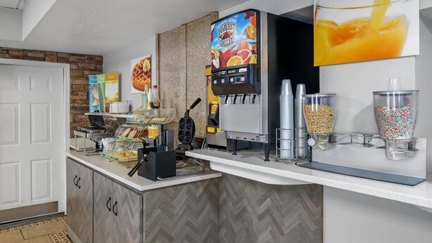 A self-service beverage station with a coffee machine, a juice dispenser, and a milk frother. - Quality Inn Bowling Green South (Bowling Green)