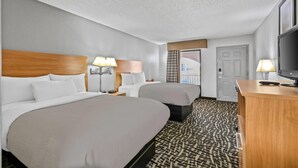 A hotel room with two beds, a desk, a TV, and a window with a city view. - Quality Inn Bowling Green South (Bowling Green)