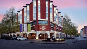 A hotel with a modern design, featuring a prominent entrance and multiple floors. - DoubleTree by Hilton Hannover Schweizerhof (Hannover)