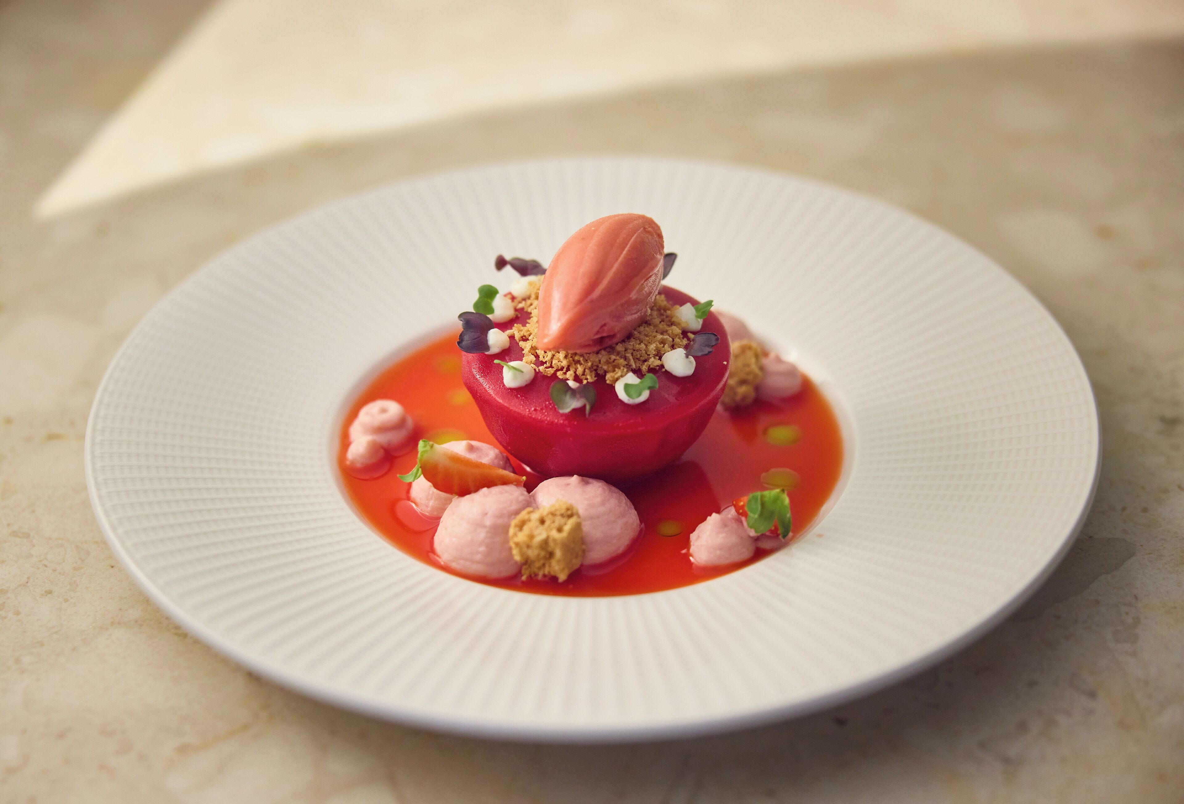 A dessert on a white plate with a textured rim.