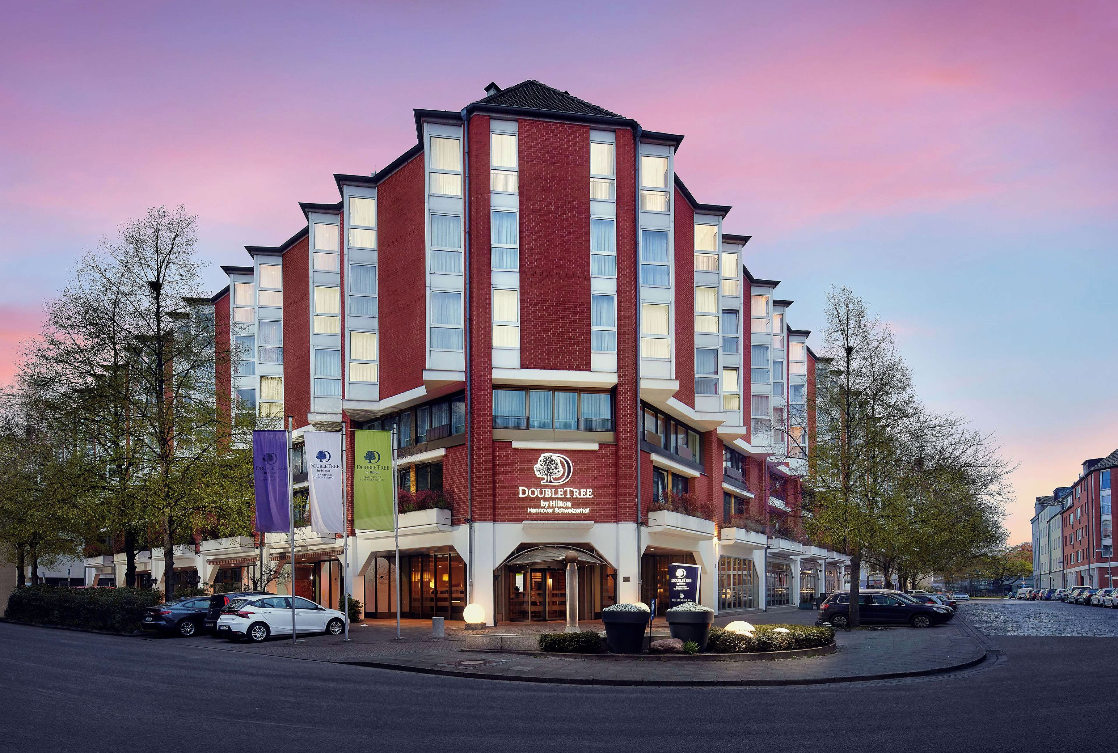 A multi-story hotel with a prominent DoubleTree logo, featuring a modern architectural design with a mix of brick and glass facades.