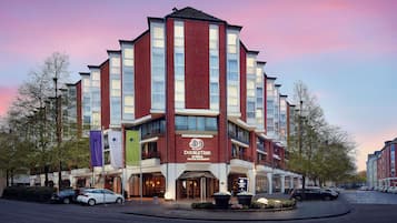 A multi-story hotel with a prominent DoubleTree logo, featuring a modern architectural design with a mix of brick and glass facades.