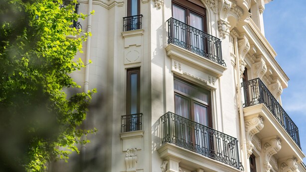 Un edificio histórico con detalles arquitectónicos ornamentales, incluyendo un tejado mansard y balcones decorativos.