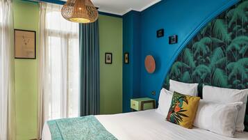 Un dormitorio con cama, mesita de noche y lámpara colgante.