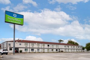 A multi-story hotel with a large sign for SureStay by BEST WESTERN.