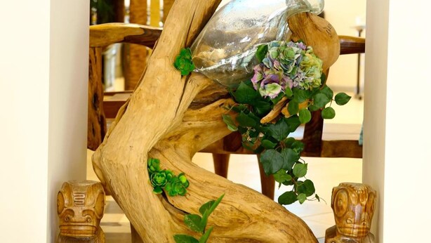 A decorative wooden sculpture with a glass vase and flowers. - Hôtel Esprit d'Azur (Nice)