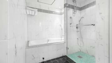 A modern bathroom with a bathtub, shower, and a small tiled area.