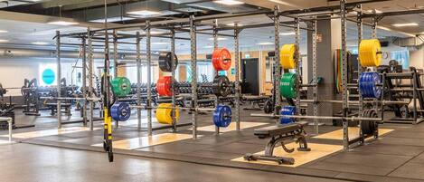 A gym with various weightlifting equipment, including barbells and weight plates.