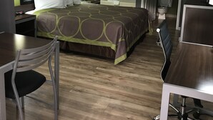 A hotel room with a bed, a desk, a chair, a shower, and a toilet. - Super 8 by Wyndham Slidell (Slidell)