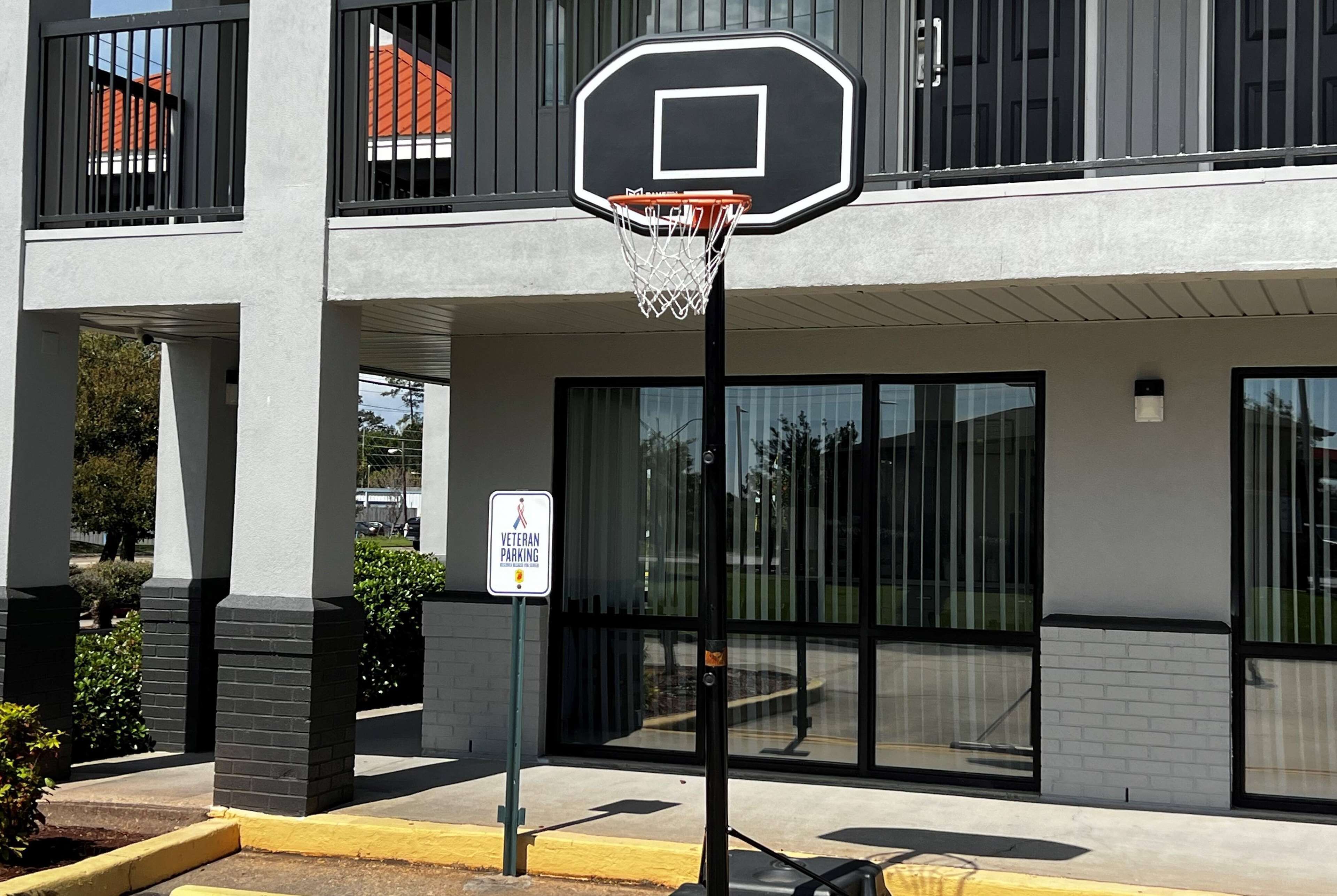 En basketkorg framför en byggnad med en skylt som visar en parkeringsplats reserverad för veteraner.