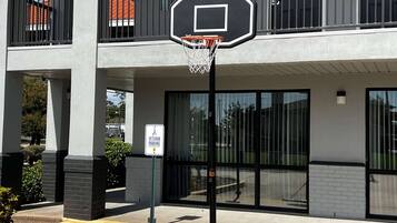 En basketkorg framför en byggnad med en skylt som visar en parkeringsplats reserverad för veteraner.