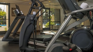 A gym with treadmills and an elliptical machine. - Knott's Hotel (Buena Park)