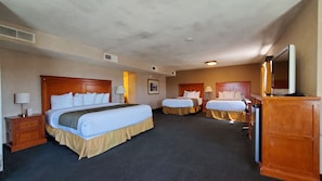 A hotel room with two beds, a desk, a chair, a television, and a bathroom. - Ramada by Wyndham Flagstaff East (Flagstaff)