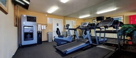 A gym with treadmills, a water dispenser, and exercise equipment.