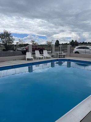 Piscine extérieure en saison, chaises longues