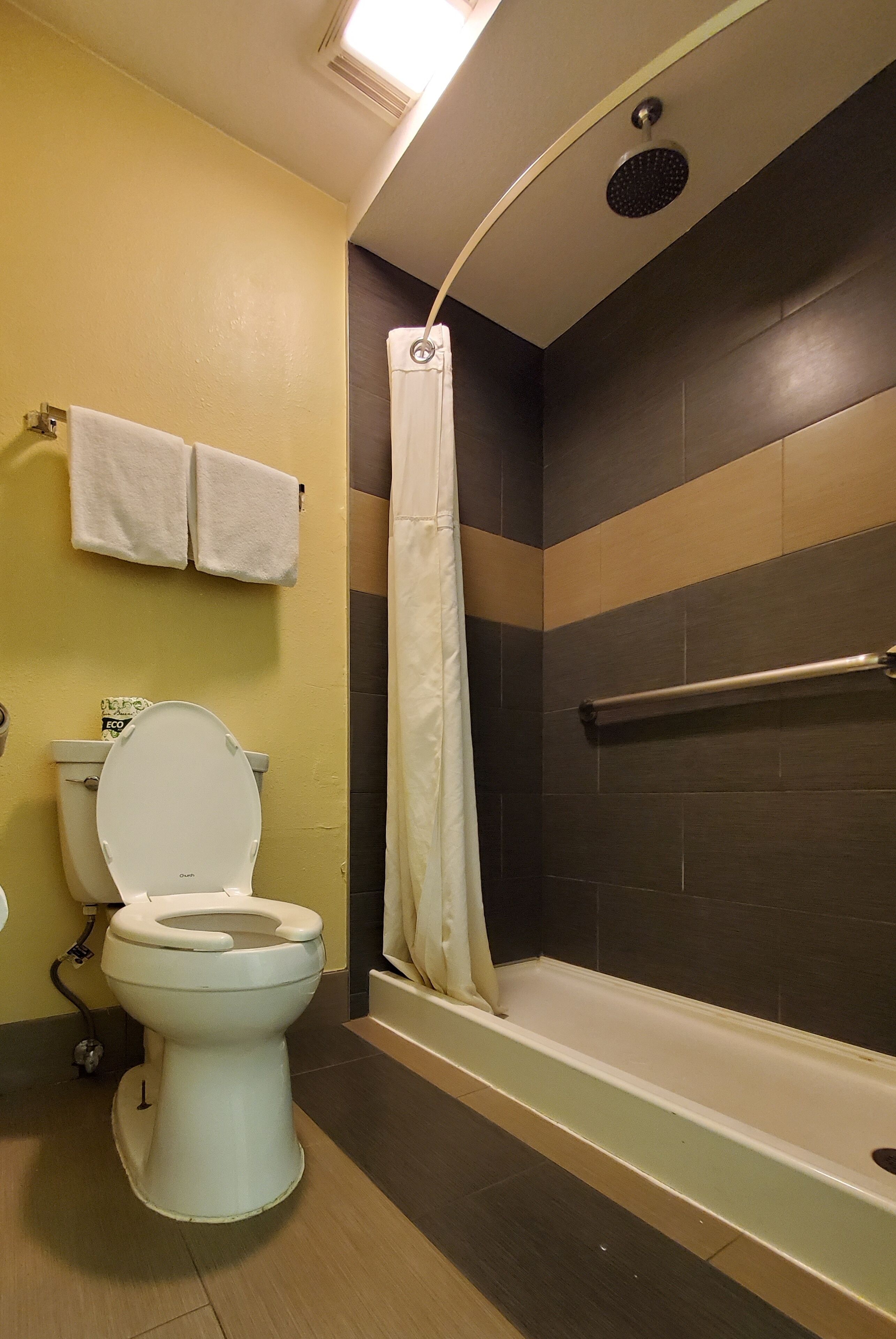 A bathroom with a toilet, a shower, and a bathtub.