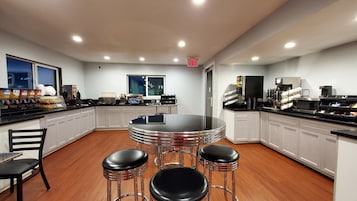 Una cocina moderna con una isla central, taburetes de bar y una cafetera.