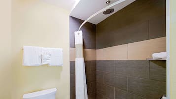 A modern bathroom with a toilet, shower, and towel rack.