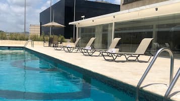 Piscine extérieure, parasols de plage, chaises longues