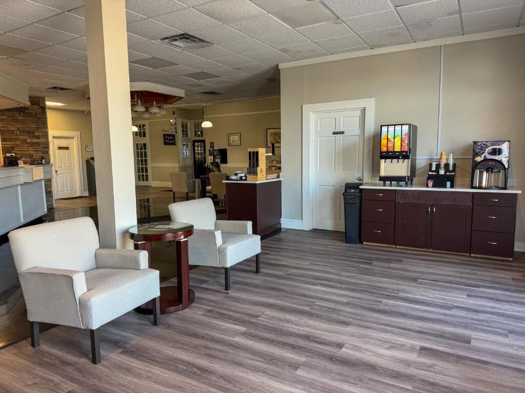 A lobby with a reception desk, seating area, and a coffee station.