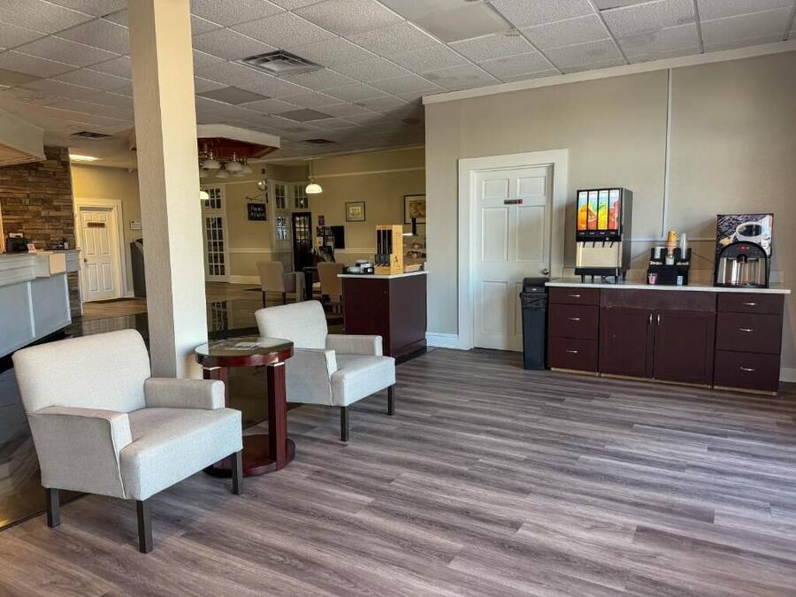 A lobby with a reception desk, seating area, and a coffee station.