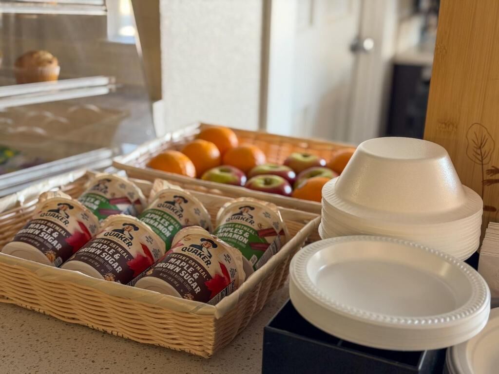 A breakfast buffet with various food items and white plates.